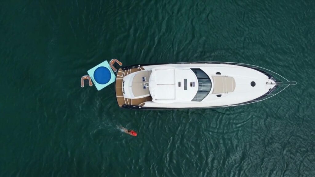Aerial view of a private charter yacht at anchor in the turquoise waters of Saint-Martin, with an inflatable platform alongside